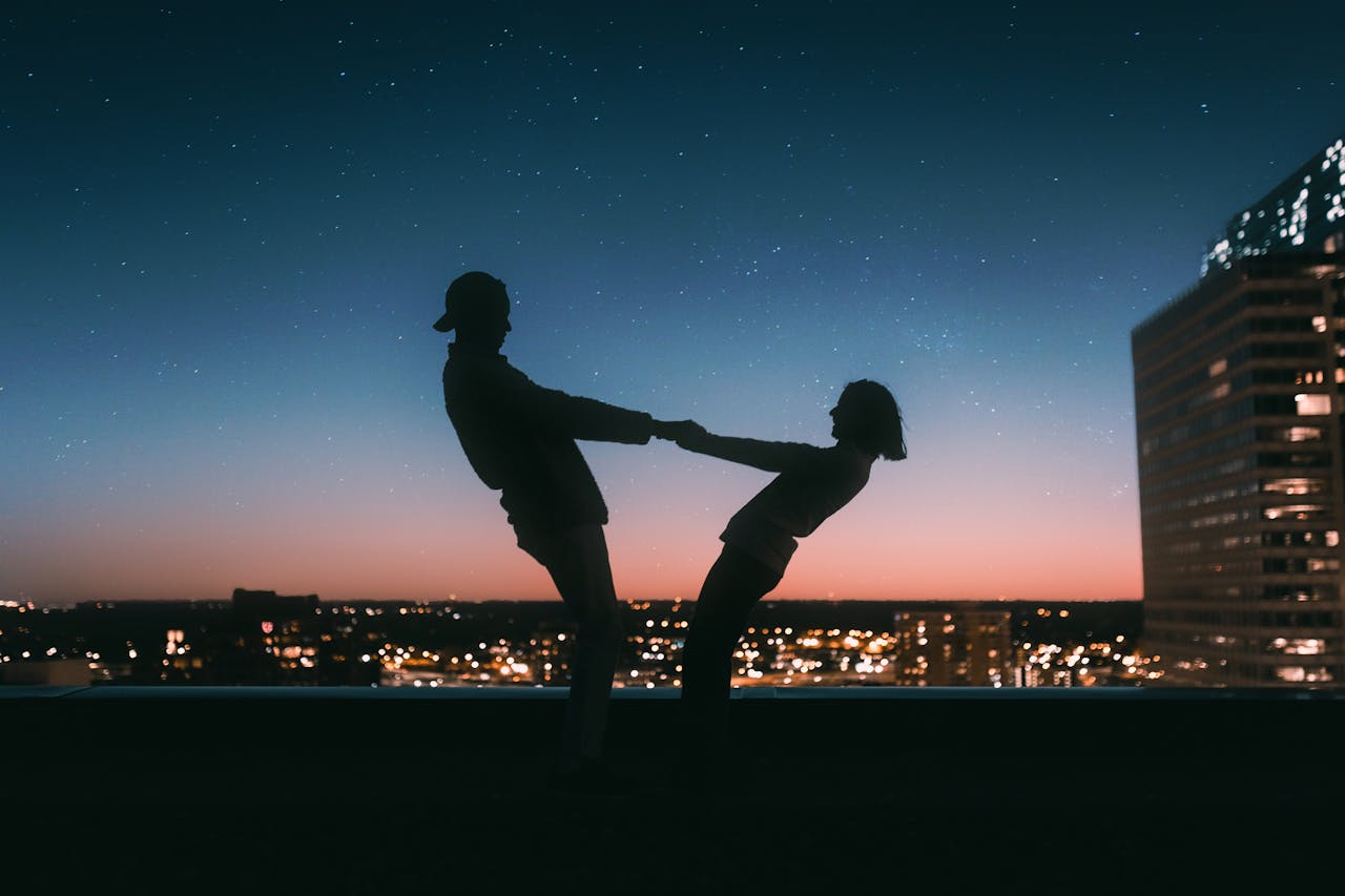 home-img A couple silhouetted against a starry sky on a rooftop in Minneapolis at sunset.
