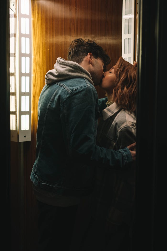 services-03 Couple sharing a romantic kiss in an intimate elevator space.
